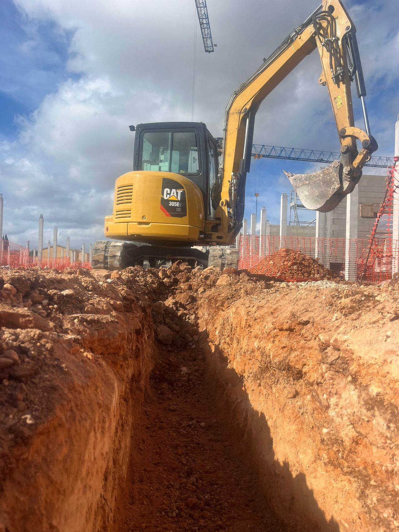 Excavadora trabajando en una zanja en obra real de JBS